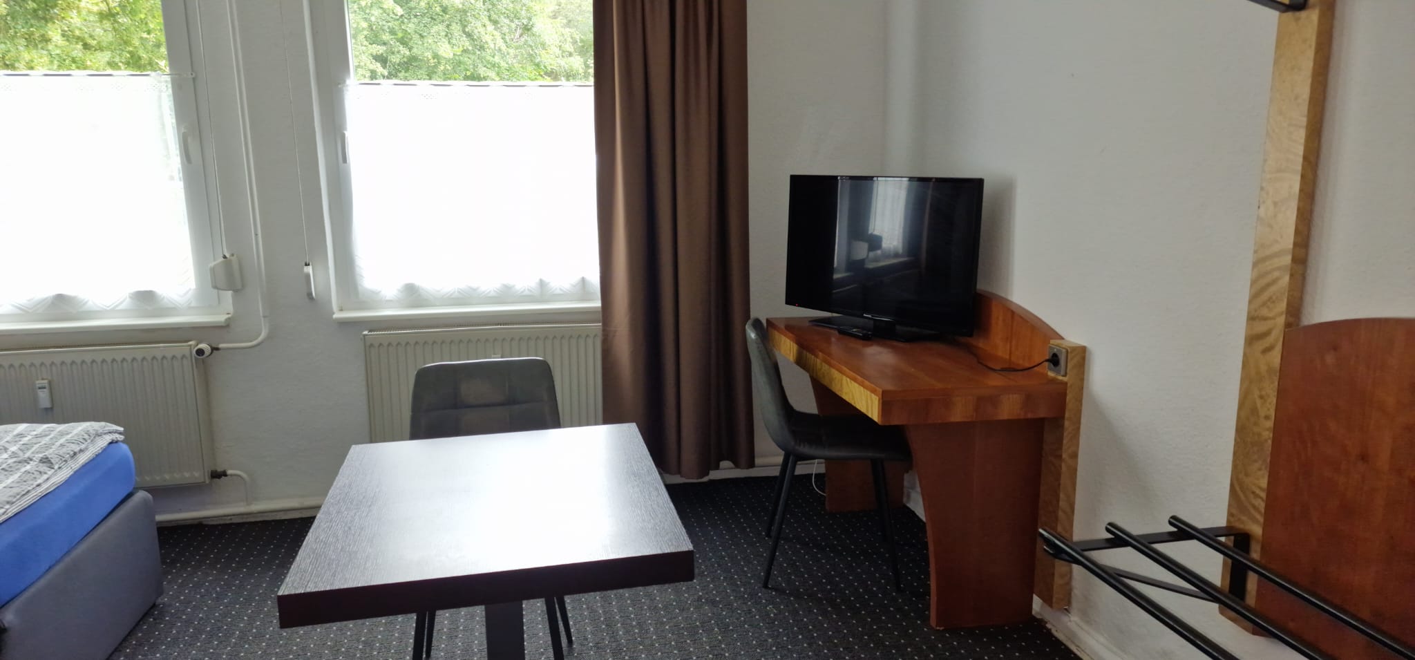 2. Schlafzimmer mit 3 Boxspringbetten, TV, Schreibtisch, Tisch und Stühlen, Hotelsafe