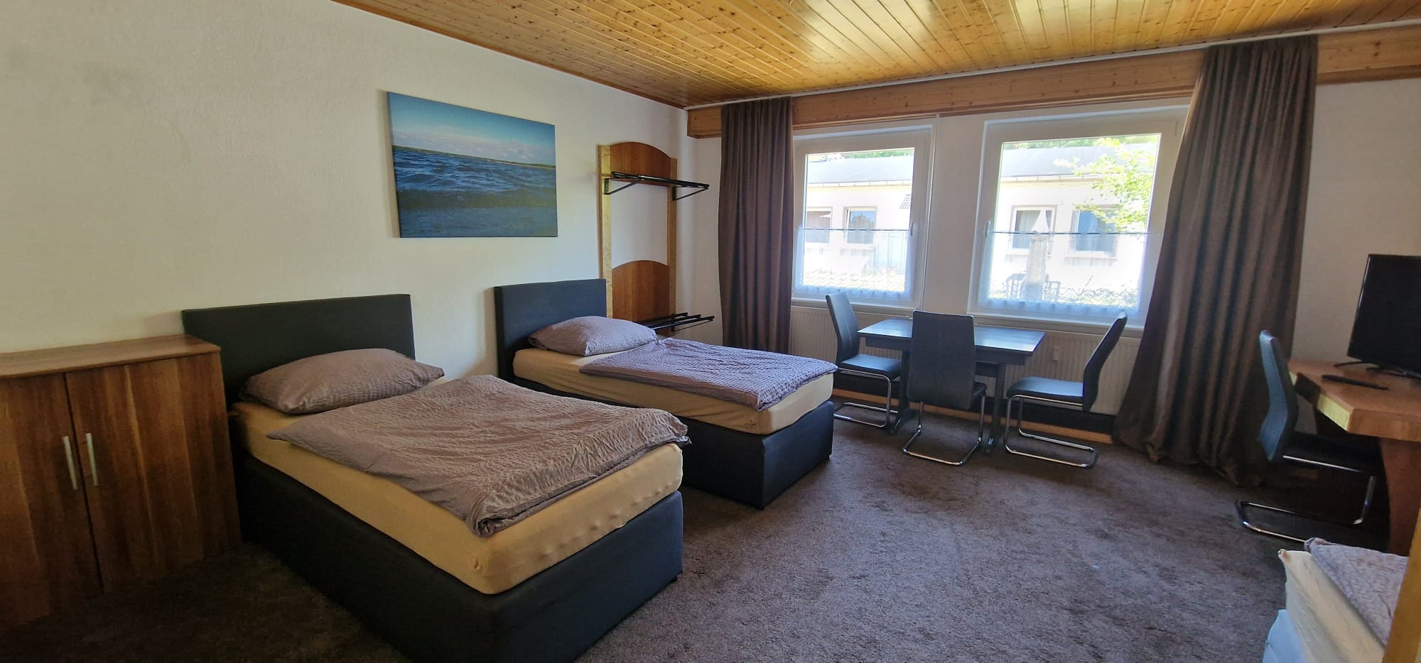 2. Schlafzimmer mit 3 Boxspringbetten, TV, Schreibtisch, Tisch und Stühlen, Hotelsafe