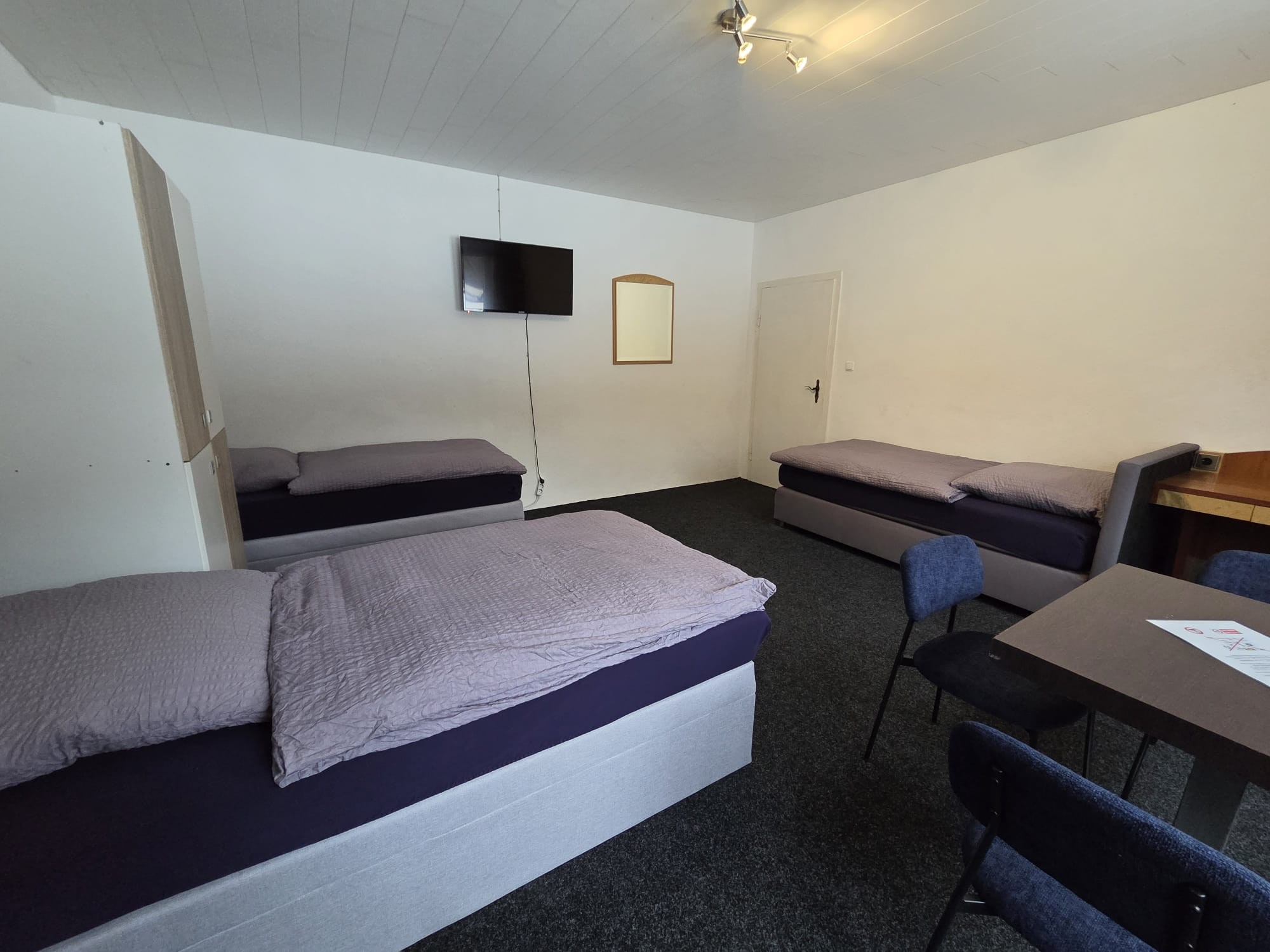 1. Schlafzimmer mit 3 Boxspringbetten, TV, Schreibtisch, Tisch und Stühlen