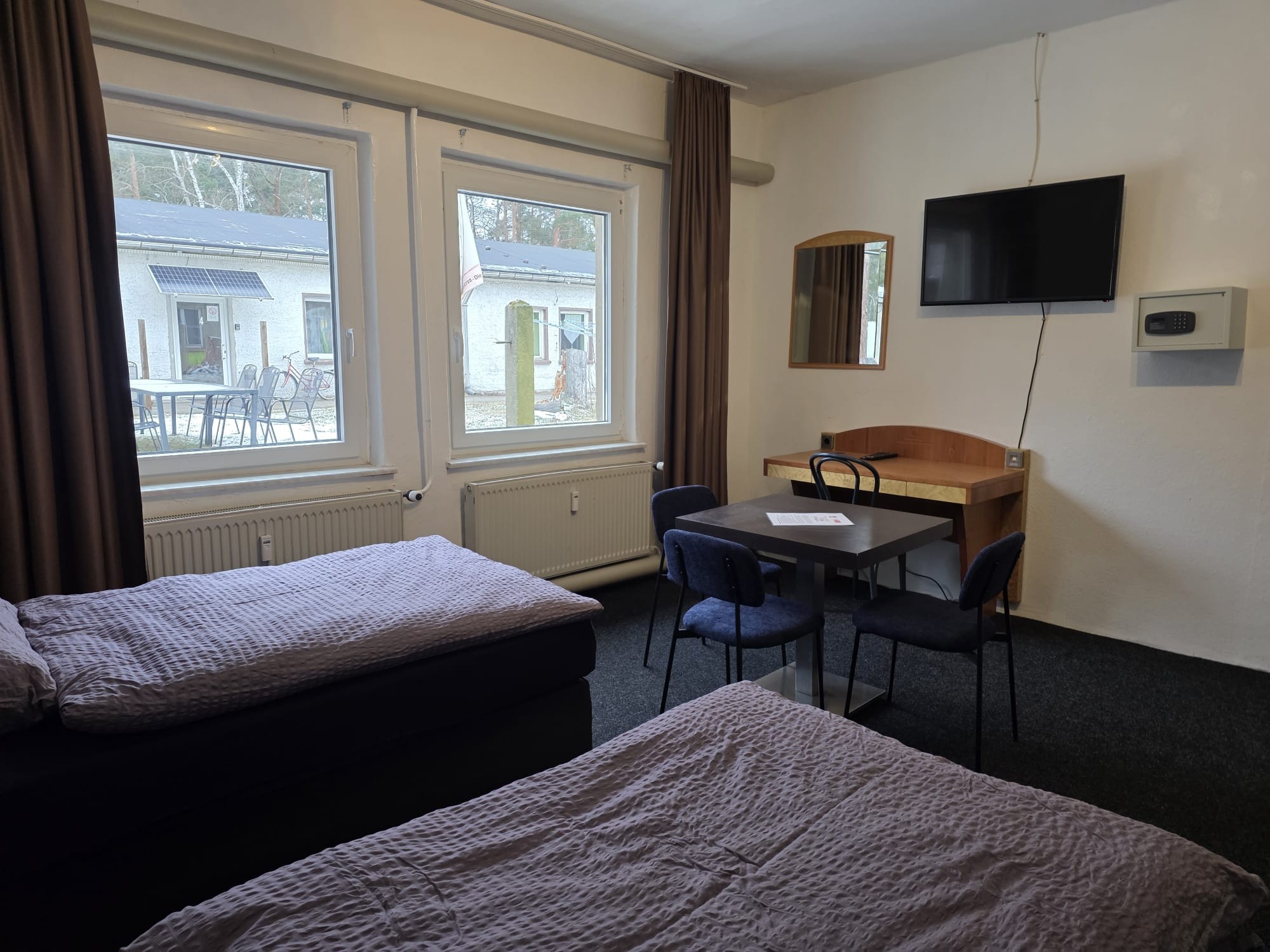 2. Schlafzimmer mit 3 Boxspringbetten, TV, Schreibtisch, Tisch und Stühlen, Hotelsafe